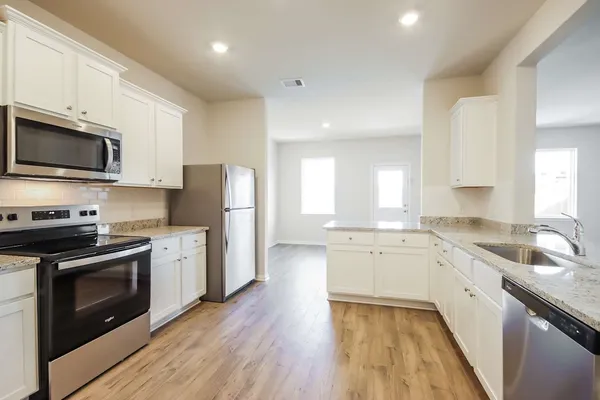a kitchen with granite countertop white cabinets and a sink