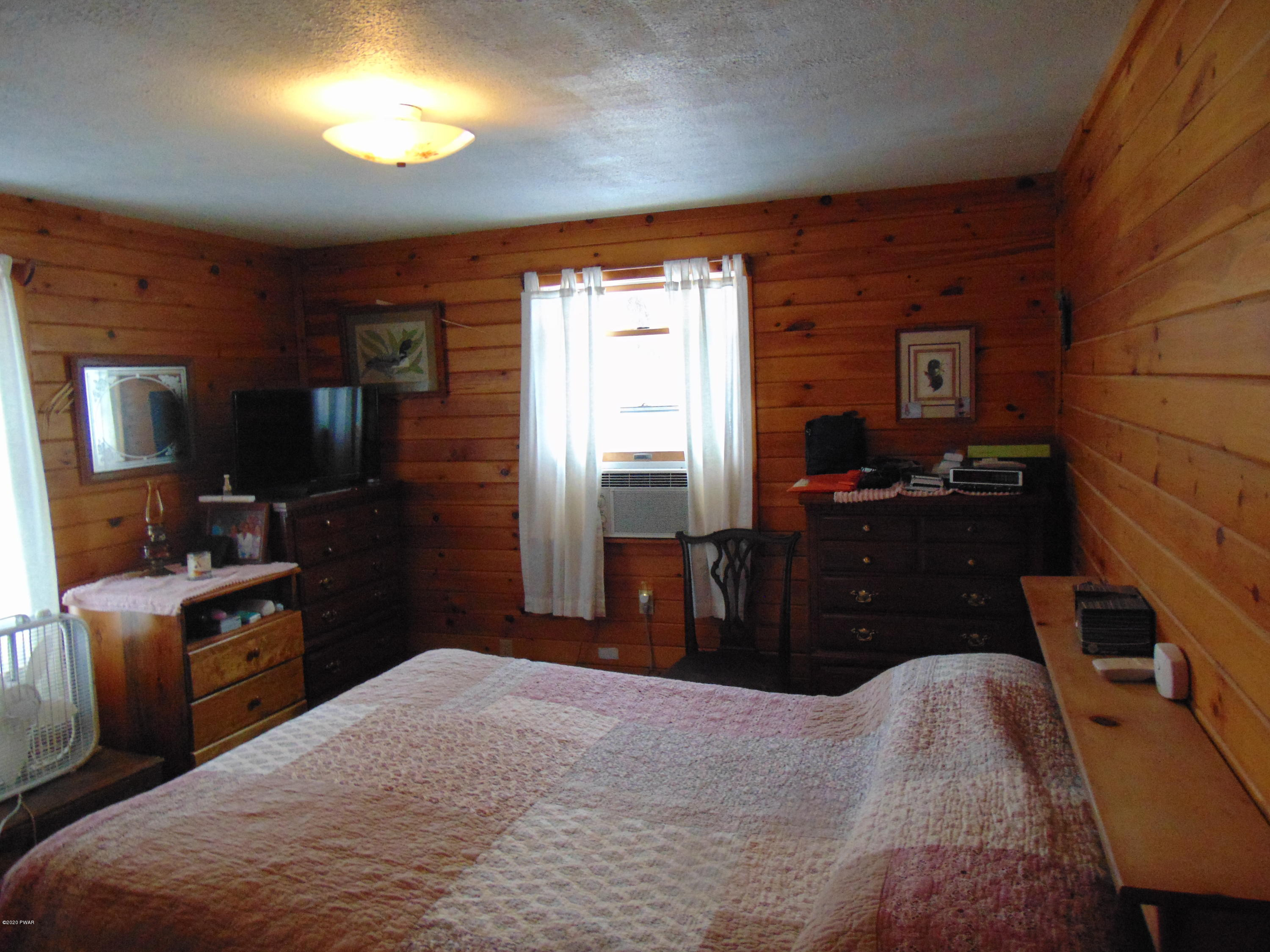 135 Puzo Road Montrose, PA 18801 - Photo 27 of 32 a bedroom with a bed and a flat tv screen on dresser