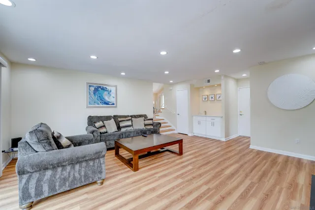 a living room with furniture and a wooden floor