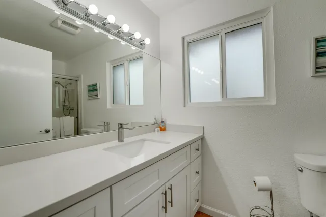 a bathroom with a sink a toilet and a mirror