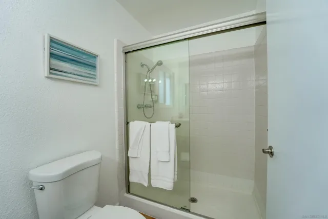 a bathroom with a shower a toilet and sink