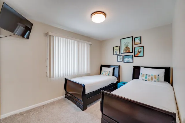 a bedroom with two beds and a window