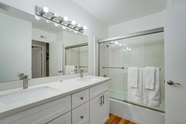 a bathroom with a double vanity sink mirror and shower