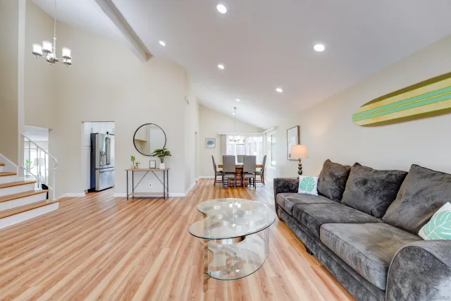 a living room with furniture a rug and kitchen view