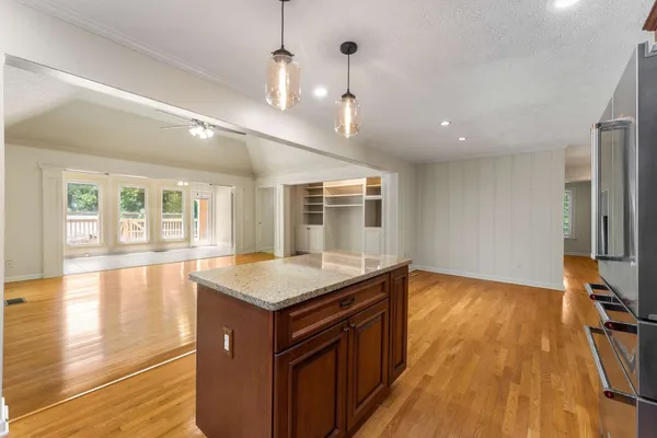 a kitchen with stainless steel appliances granite countertop a sink a stove and a wooden floors