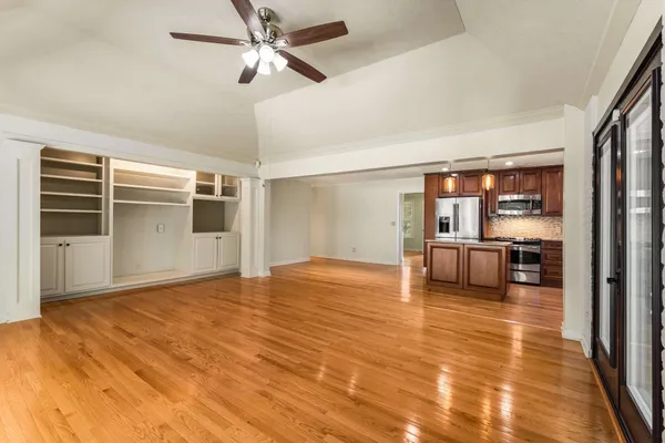 a view of empty room with wooden floor and fireplace