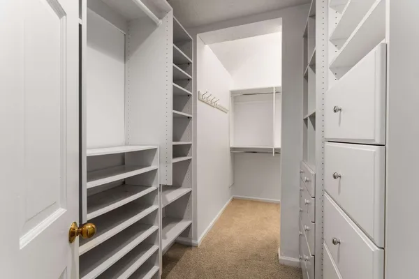 a view of walk in closet with empty racks