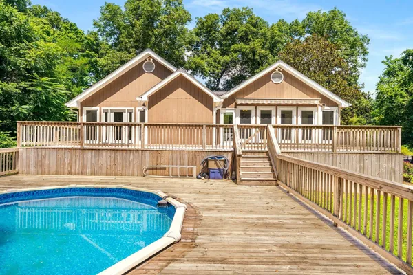 a view of a house with wooden deck and a yard