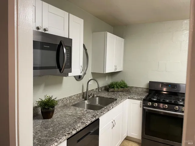 a kitchen with a sink and a stove top oven