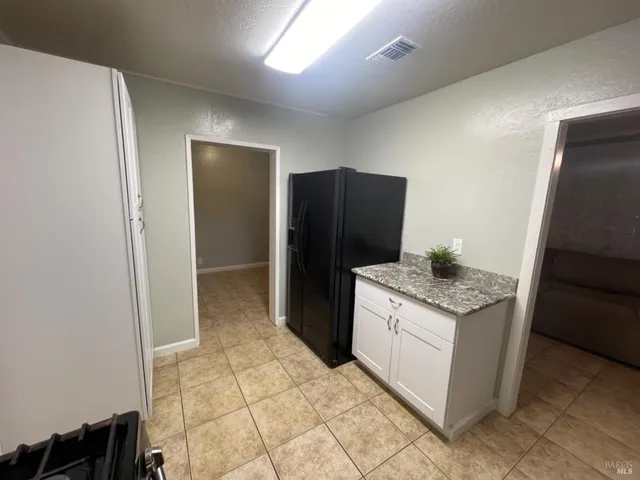 a kitchen with granite countertop a refrigerator and a stove
