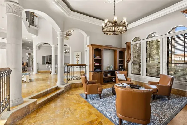 a living room with stainless steel appliances furniture and a kitchen view