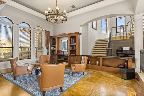 a spacious bedroom with a bed a couch and a chandelier