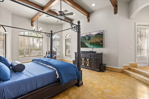 a bedroom with a bed and a flat tv screen on dresser