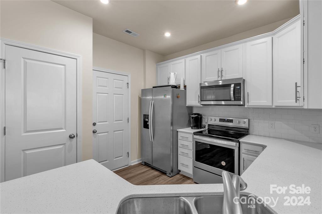 825 Canoe Song Road Fort Mill, SC 29708 - Photo 6 of 17 a kitchen with white cabinets and stainless steel appliances