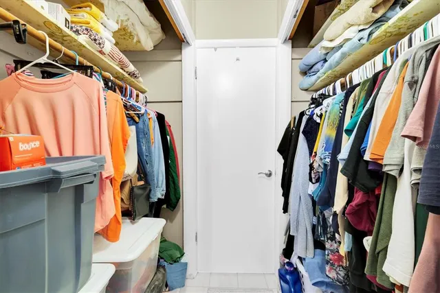 a view of walk in closet with clothes and shoes