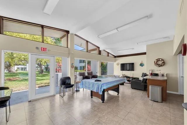 a living room with furniture flat screen tv and a large window