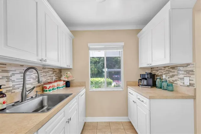 a kitchen with granite countertop a sink a counter space and cabinets