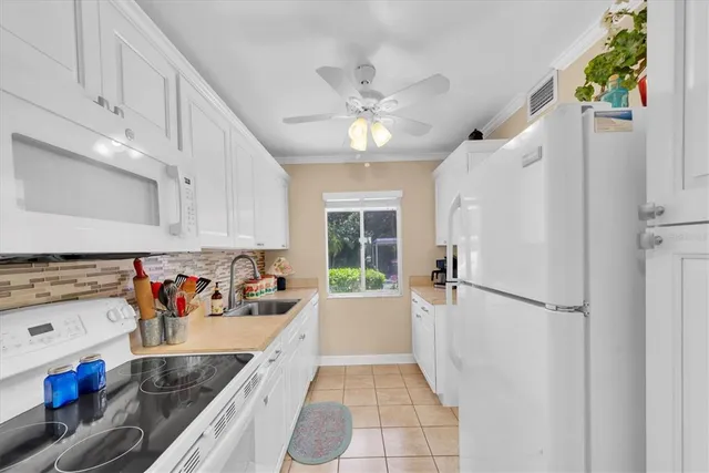 a kitchen with stainless steel appliances granite countertop a refrigerator a sink dishwasher a stove and a dining table with wooden floor