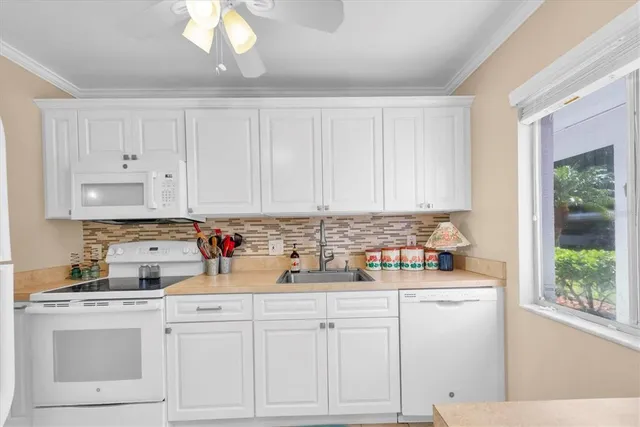a kitchen with white cabinets and white appliances