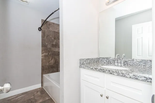 a bathroom with a granite countertop sink and a mirror