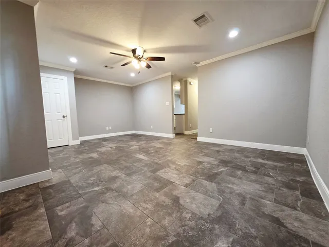 an empty room with fan and windows