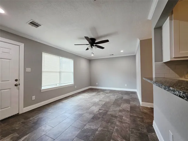 a view of a livingroom with a ceiling fan & window