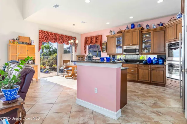a kitchen with stainless steel appliances kitchen island granite countertop a table and chairs in it