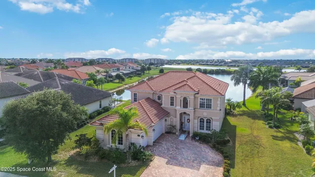an aerial view of a city with lots of residential buildings ocean and mountain view in back