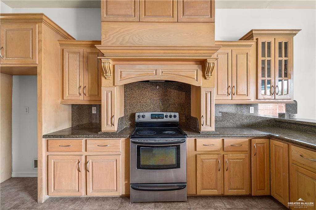 2913 San Rodrigo Mission, TX 78572 - Photo 11 of 29 a kitchen with granite countertop a stove oven and white cabinets