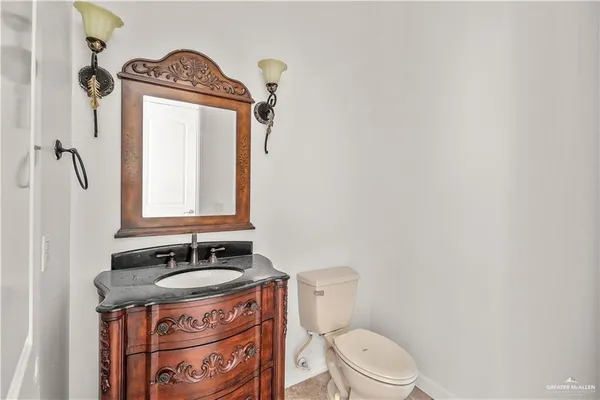 a bathroom with a granite countertop sink toilet a mirror a vanity and shower