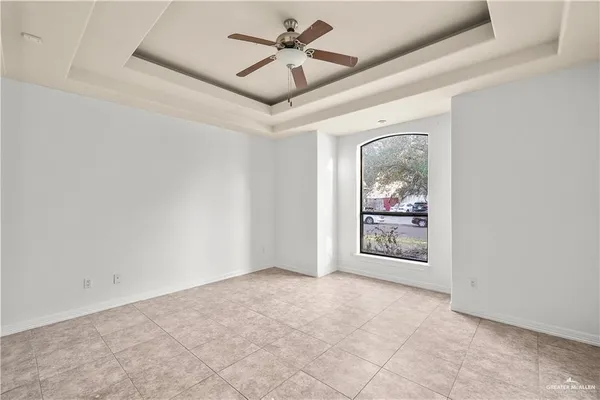 a view of an empty room with a ceiling fan and window