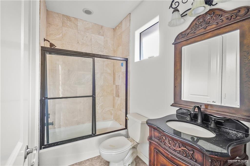 2913 San Rodrigo Mission, TX 78572 - Photo 21 of 29 a bathroom with a granite countertop sink toilet a mirror a vanity and shower