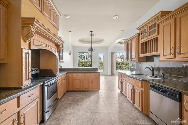 a kitchen with granite countertop a stove oven and white cabinets