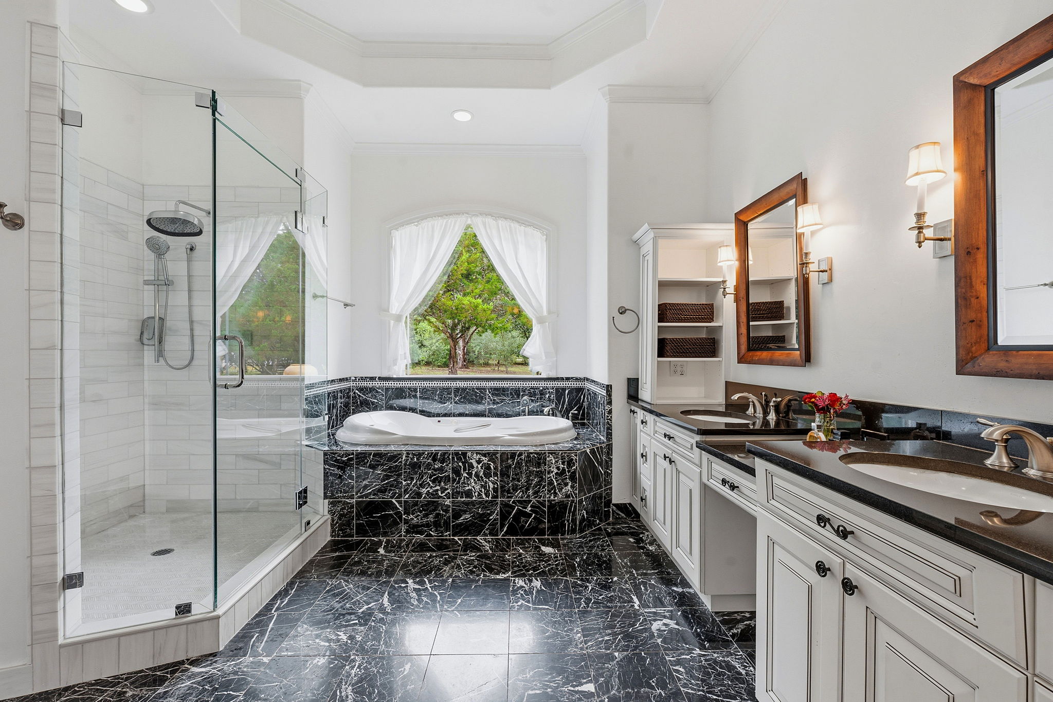8121 Bluff Trail Austin, TX 78737 - Photo 25 of 40 Luxurious primary bath showcasing a deep soaking tub and a spacious walk-in shower with black marble flooring.