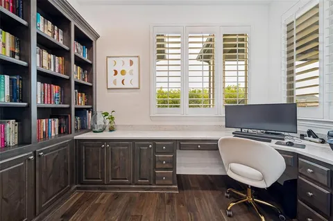 a workspace with a bookshelf window and wooden floor