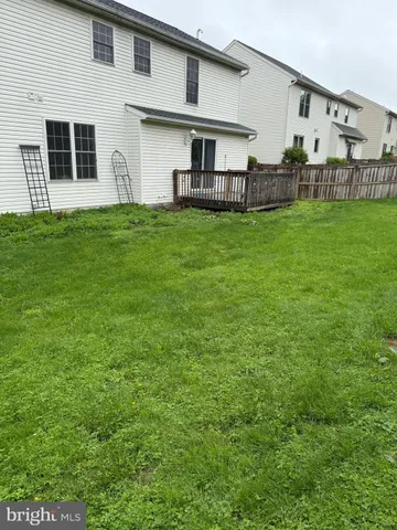 a front view of house with yard and trees in the background