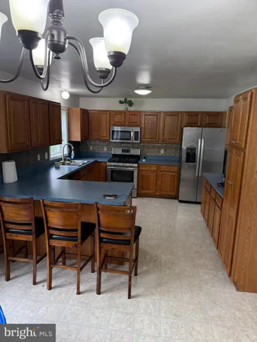 a kitchen with cabinets a counter and chairs