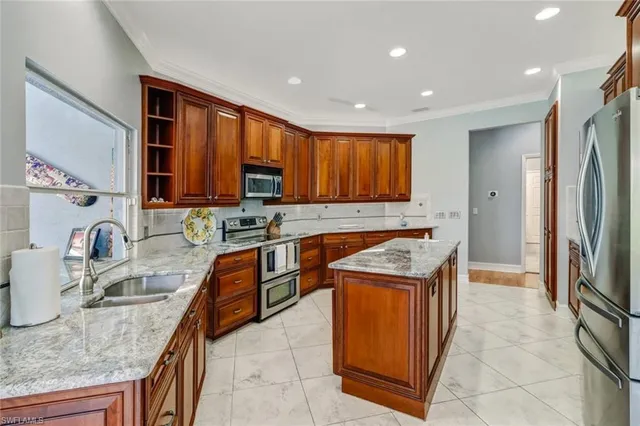 a kitchen with stainless steel appliances granite countertop a sink stove and refrigerator