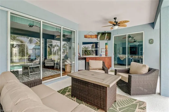 a living room with furniture a floor to ceiling window and a flat screen tv
