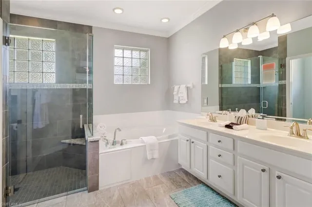 a bathroom with a double vanity sink toilet mirror and bathtub