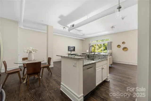 a kitchen with stainless steel appliances a table and chairs in it