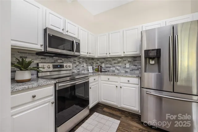 a kitchen with stainless steel appliances granite countertop a refrigerator stove and microwave