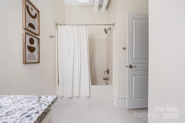 a bathroom with a granite countertop shower and a sink