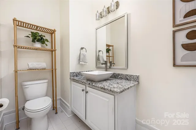 a bathroom with a granite countertop toilet sink and mirror