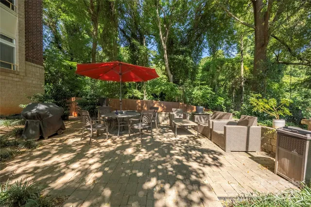 a view of a patio with table and chairs potted plants and large tree