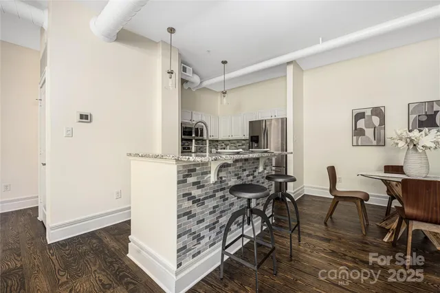 a kitchen with stainless steel appliances kitchen island granite countertop a refrigerator and cabinets