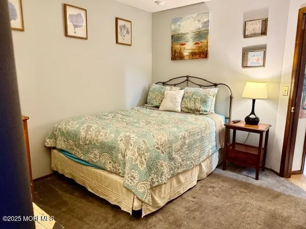 a bedroom with a large bed and a painting on the wall