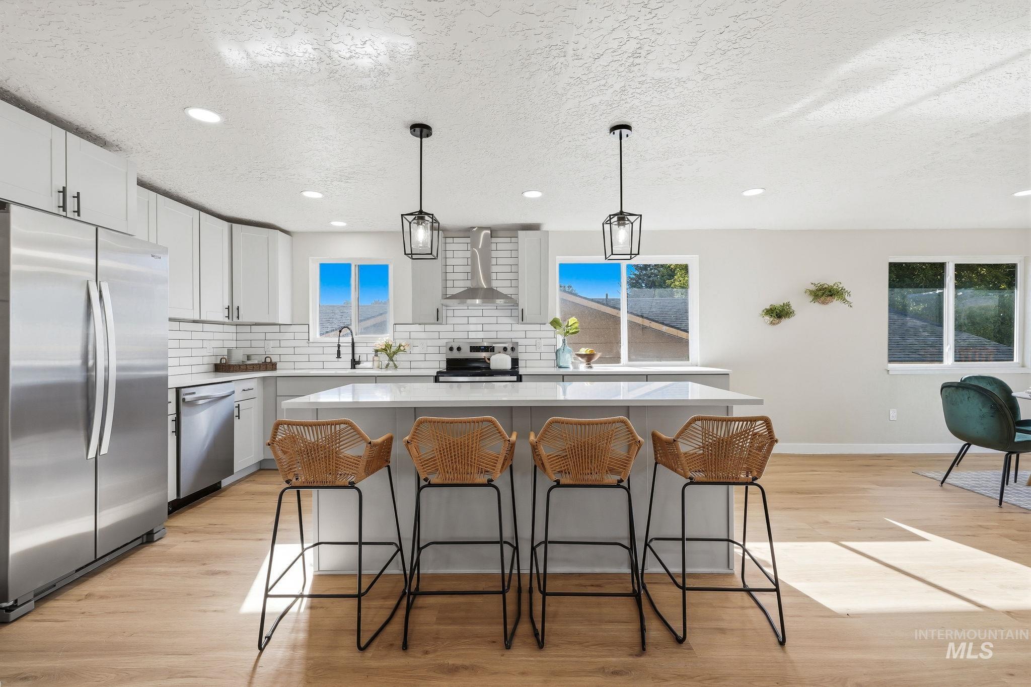 1990 Panama Street Boise, ID 83705 - Photo 19 of 50 Bright kitchen featuring a central island, recessed lighting, wood-finish flooring, white subway tile backsplash, and stainless steel appliances