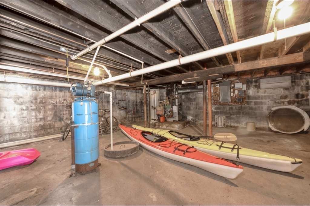 130 Scadding Street Taunton, MA 02780 - Photo 38 of 42 a storage room with water heater and racks on the wall