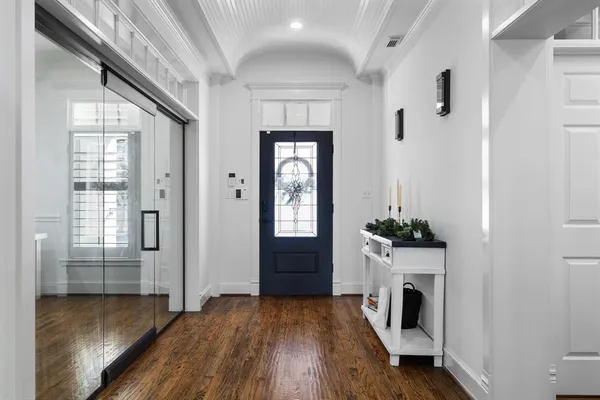 a living room with a fireplace windows and a wooden floor